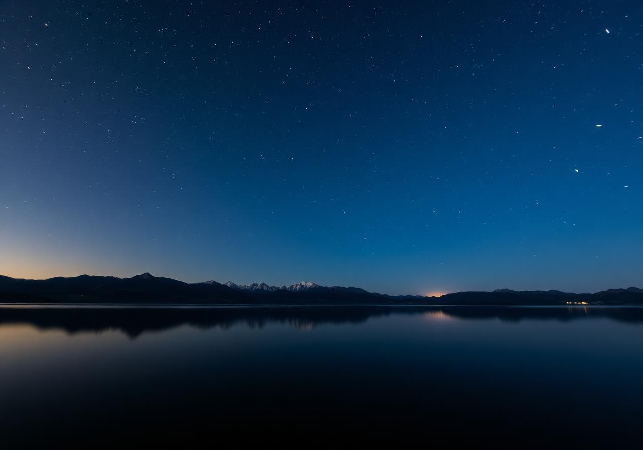 Calm mountain lake under a starry twilight sky